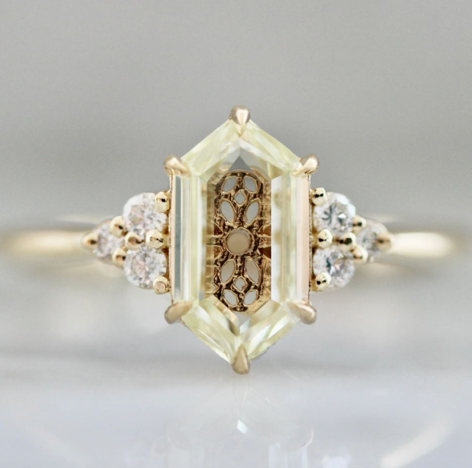 A custom engagement ring featuring a yellow portrait-cut diamond with intricate gold metalwork visible through the stone, handcrafted in 18k gold by Gem Breakfast