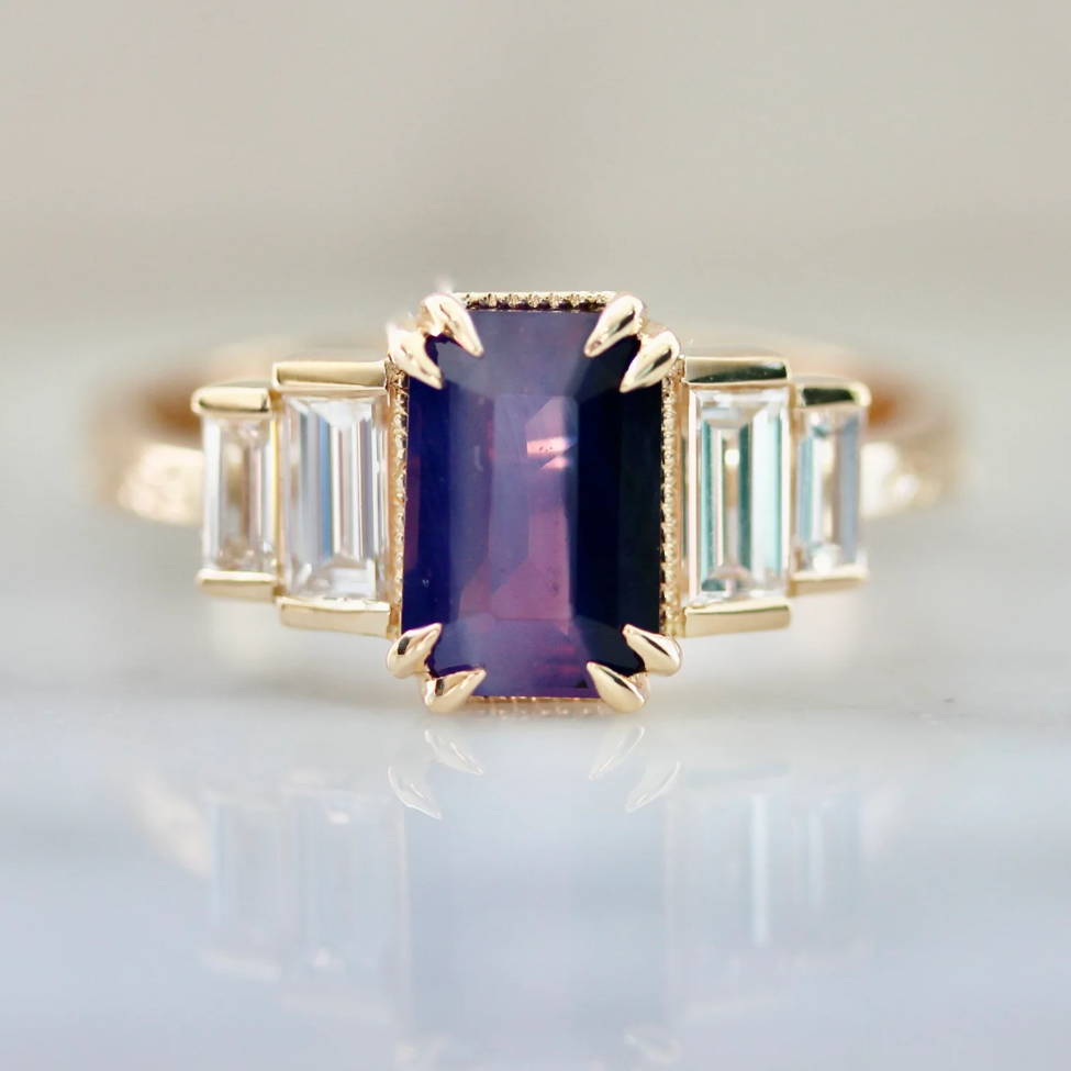 Purple emerald cut sapphire ring with baguette diamond sides