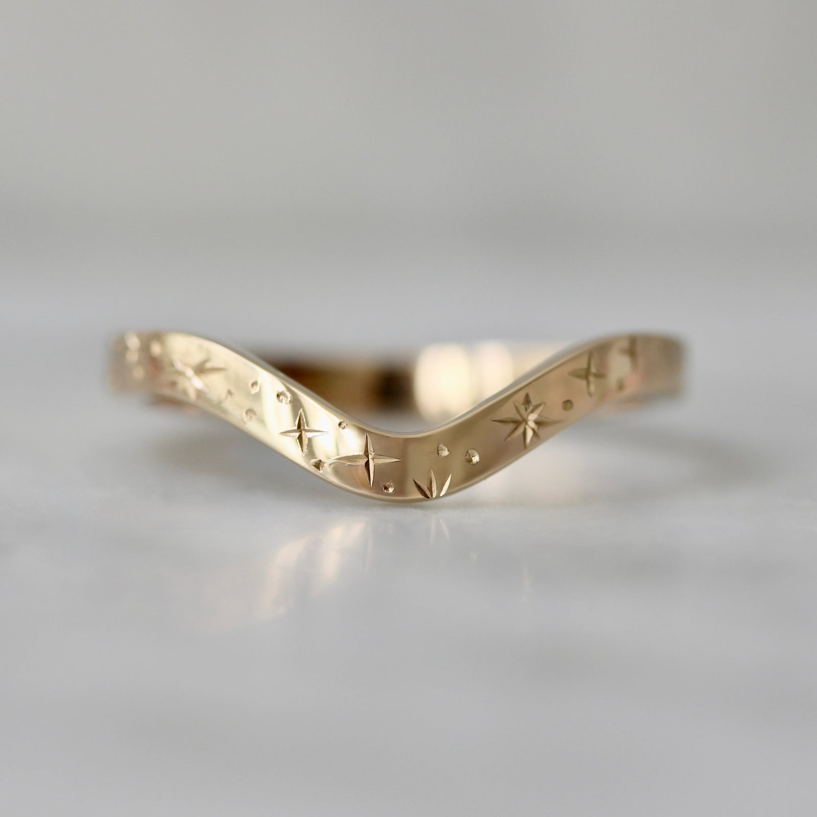 14k yellow gold custom curved wedding band with hand-engraved stars by Gem Breakfast
