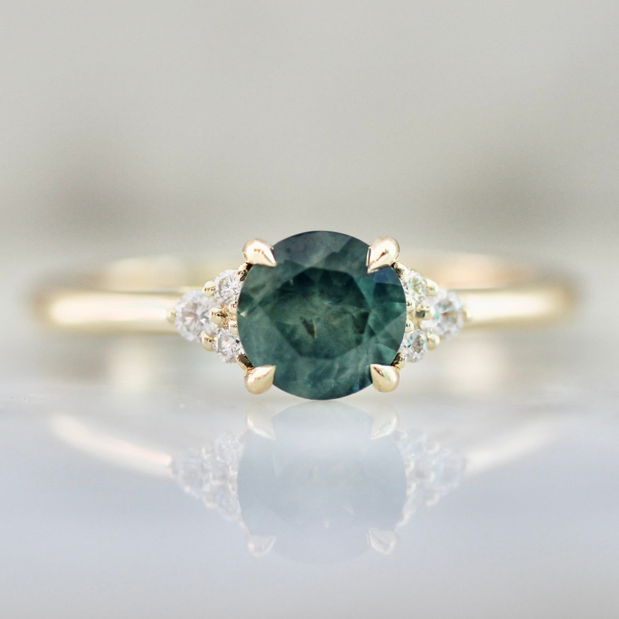 Custom round cut teal Montana sapphire engagement ring with round brilliant diamond accents by Gem Breakfast