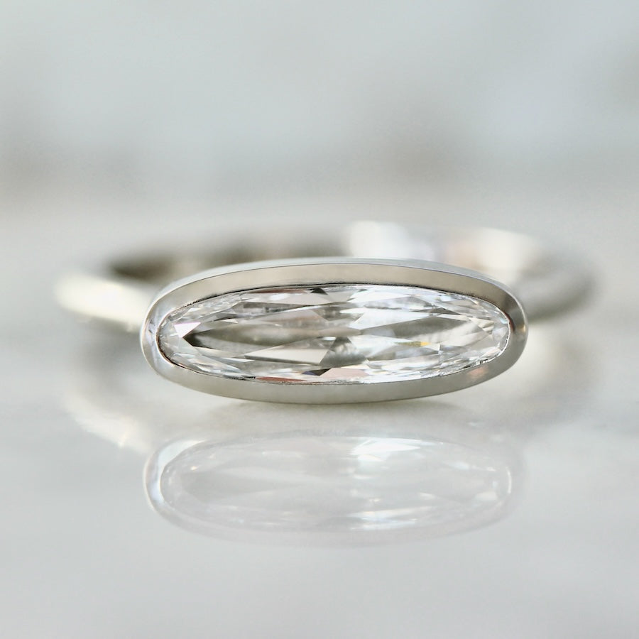 Custom engagement ring with east-west set moval diamond in a platinum bezel setting by Gem Breakfast