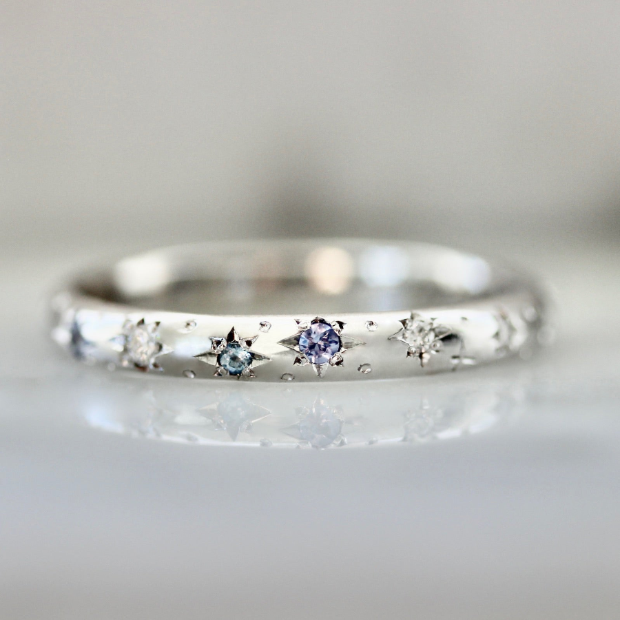 Custom wedding band with hand-engraved stars and star-set diamonds and sapphires in white gold by Gem Breakfast