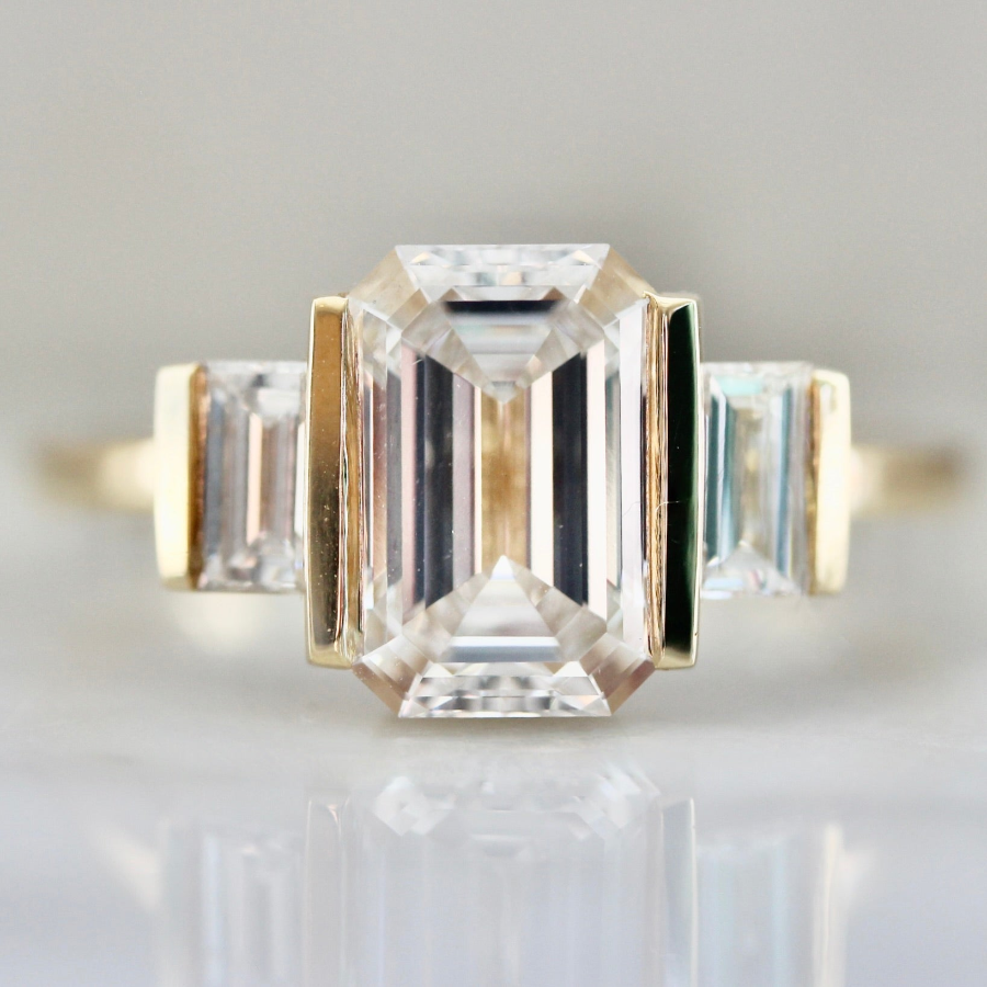 Art deco engagement ring with emerald cut diamond and baguette diamond side stones in a custom setting by Gem Breakfast