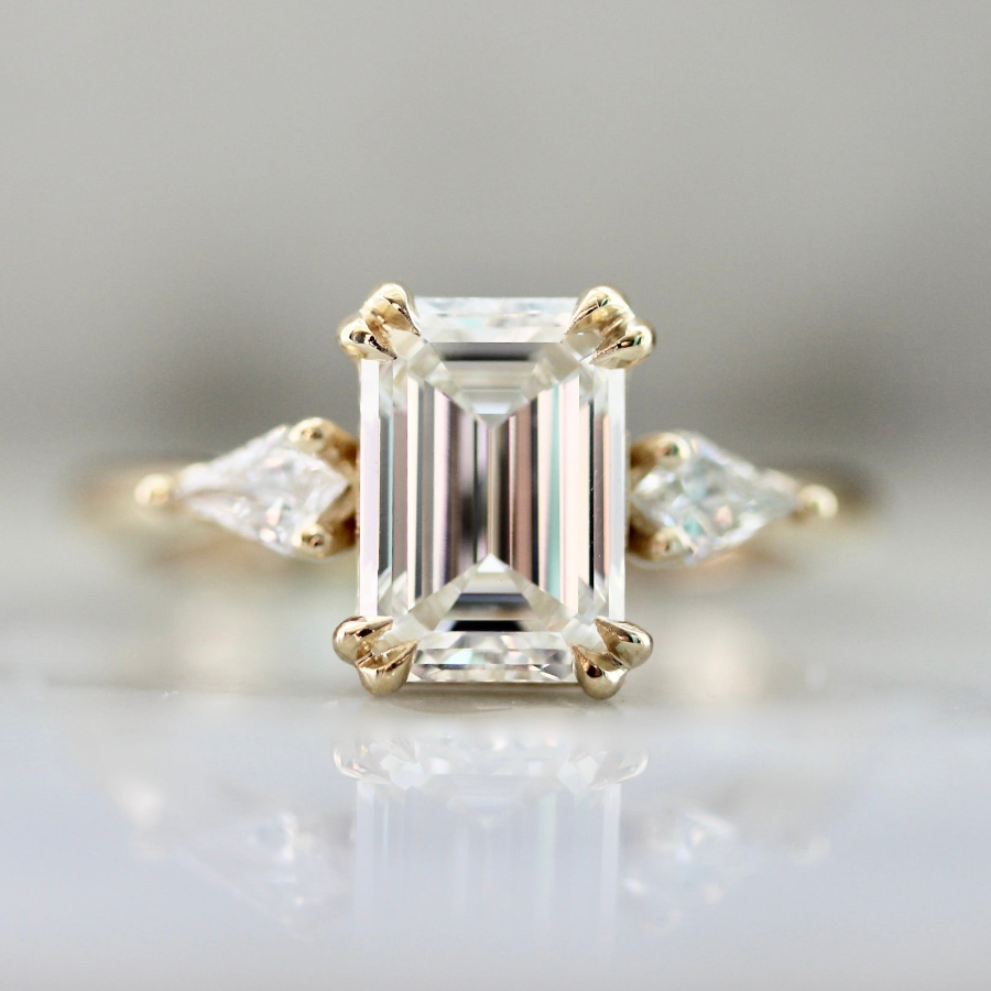 Emerald cut diamond engagement ring with kite diamond side stones and double claw prongs in a custom setting by Gem Breakfast