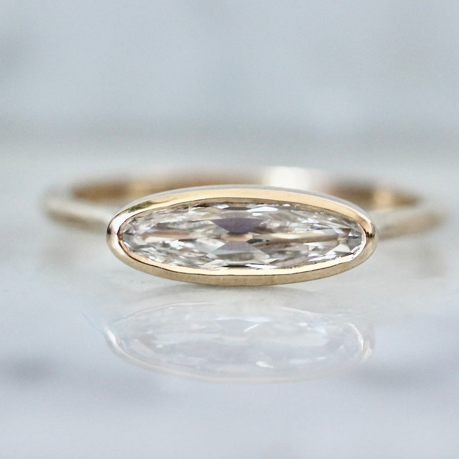 Custom engagement ring with elongated moval diamond in an east-west bezel setting by Gem Breakfast