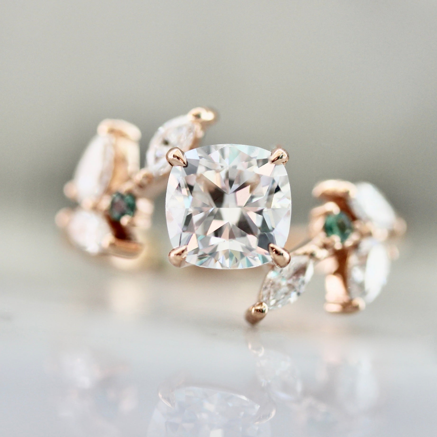 Custom nature-inspired engagement ring with cushion cut diamond and marquise diamond accents in a custom vine-like setting by Gem Breakfast