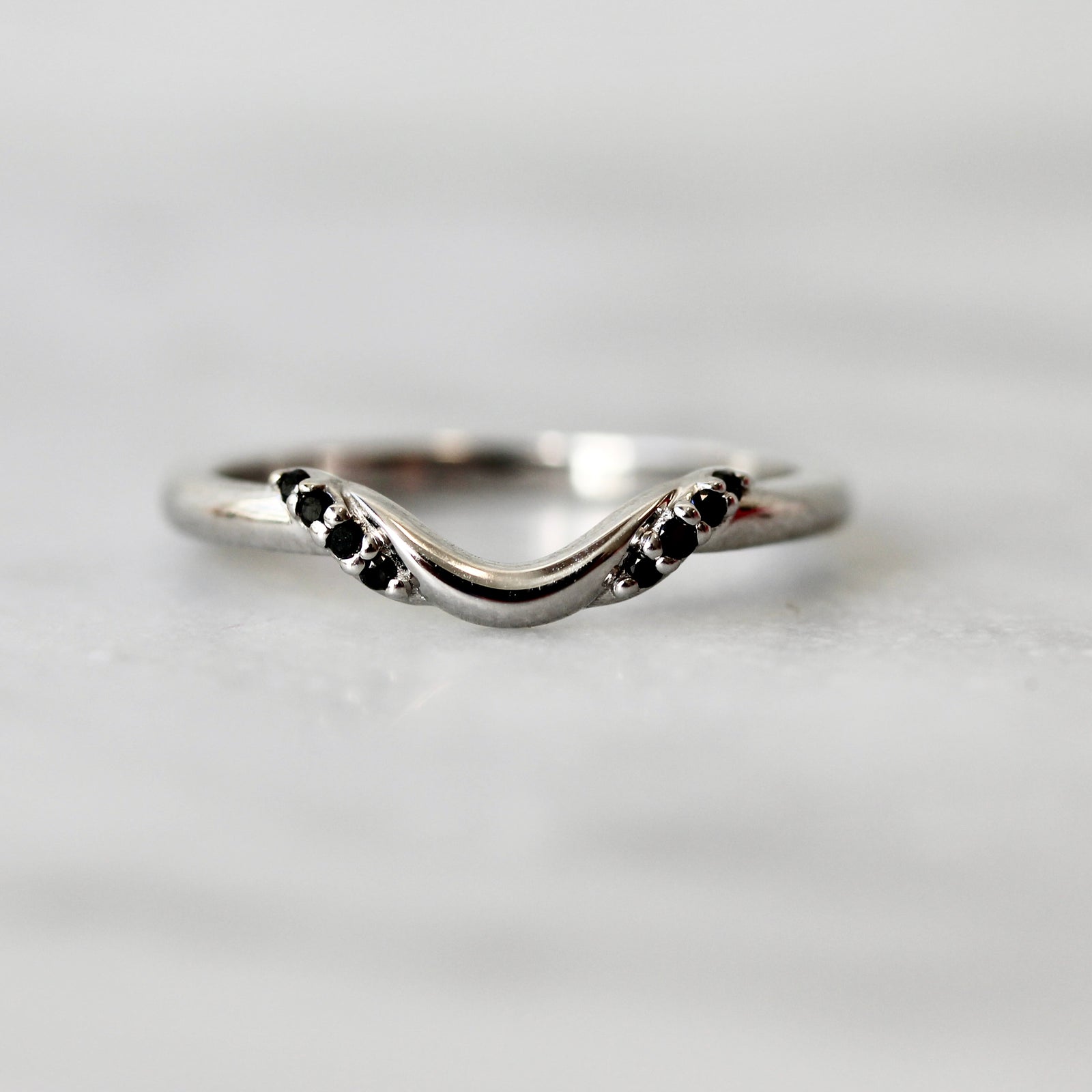 Custom curved wedding band in white gold with black diamonds by Gem Breakfast