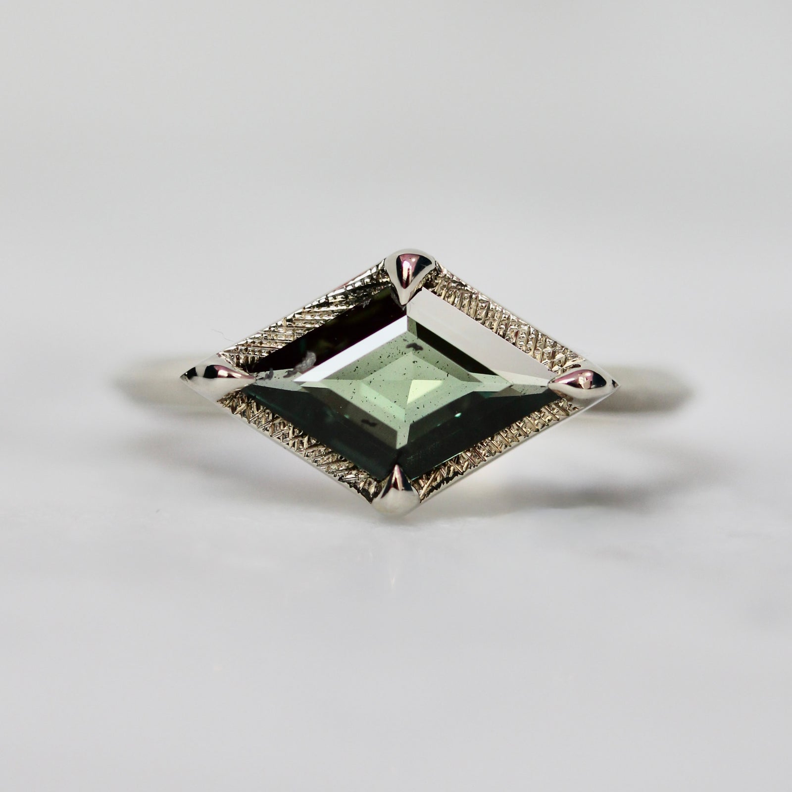 Custom engagement ring with kite cut green sapphire in a white gold setting by Gem Breakfast