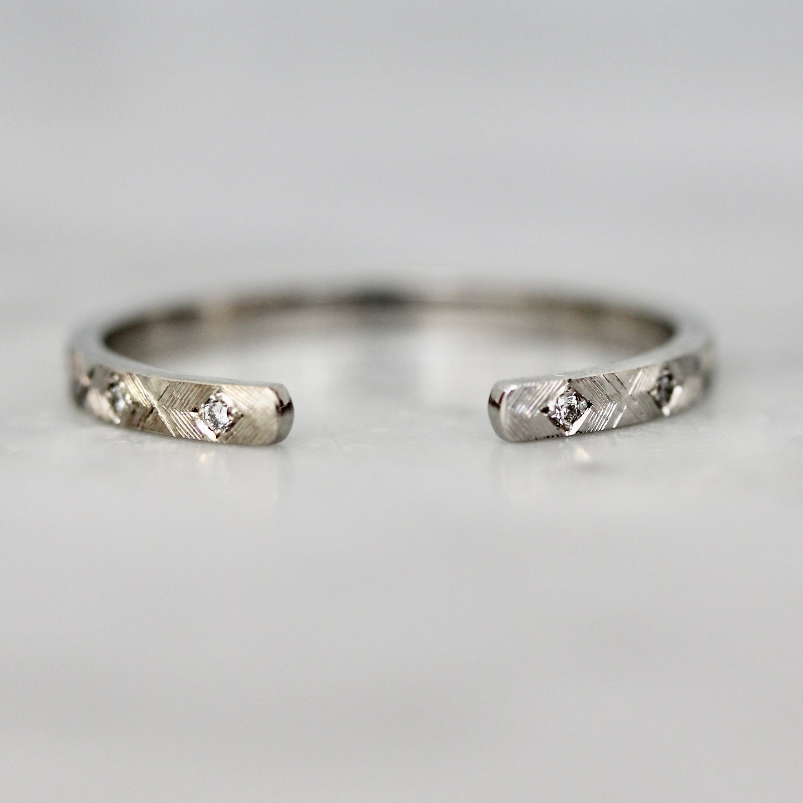 Custom wedding band in white gold with star-set diamonds and hand-engraved open cuff design by Gem Breakfast