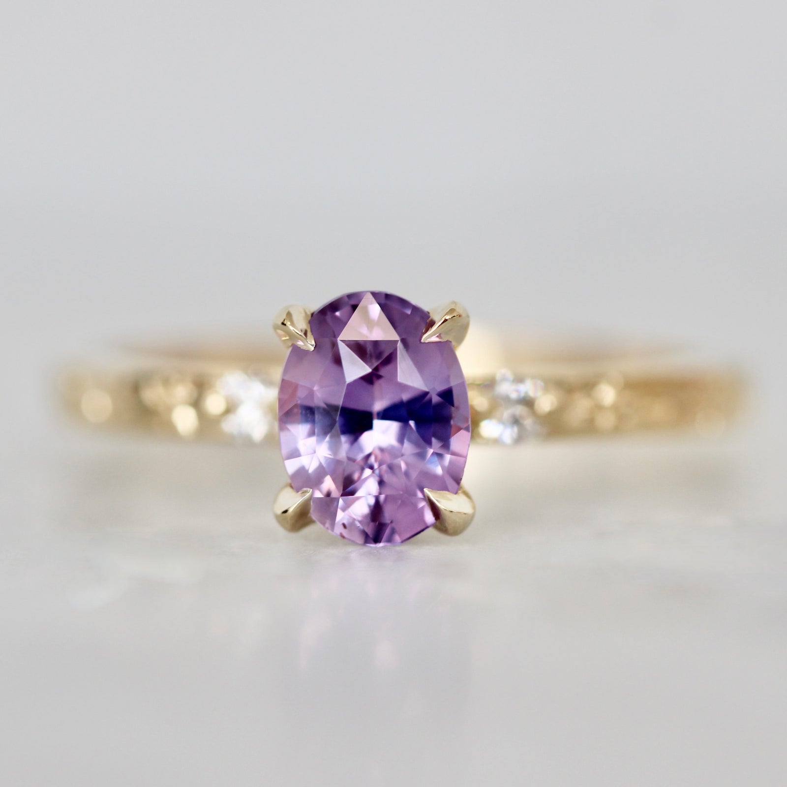 Oval cut purple sapphire custom engagement ring with pavé diamond band by Gem Breakfast