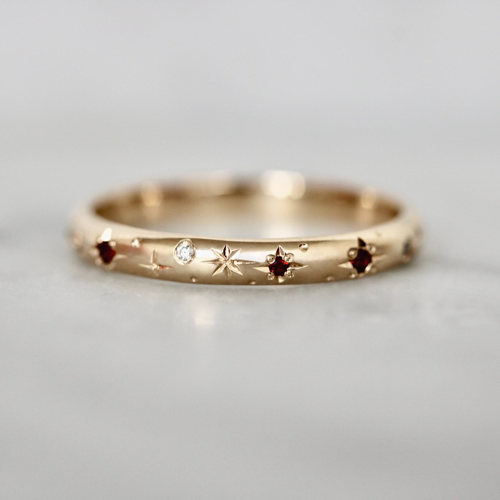 Custom wedding band with hand-engraved stars and star-set garnets and diamonds by Gem Breakfast