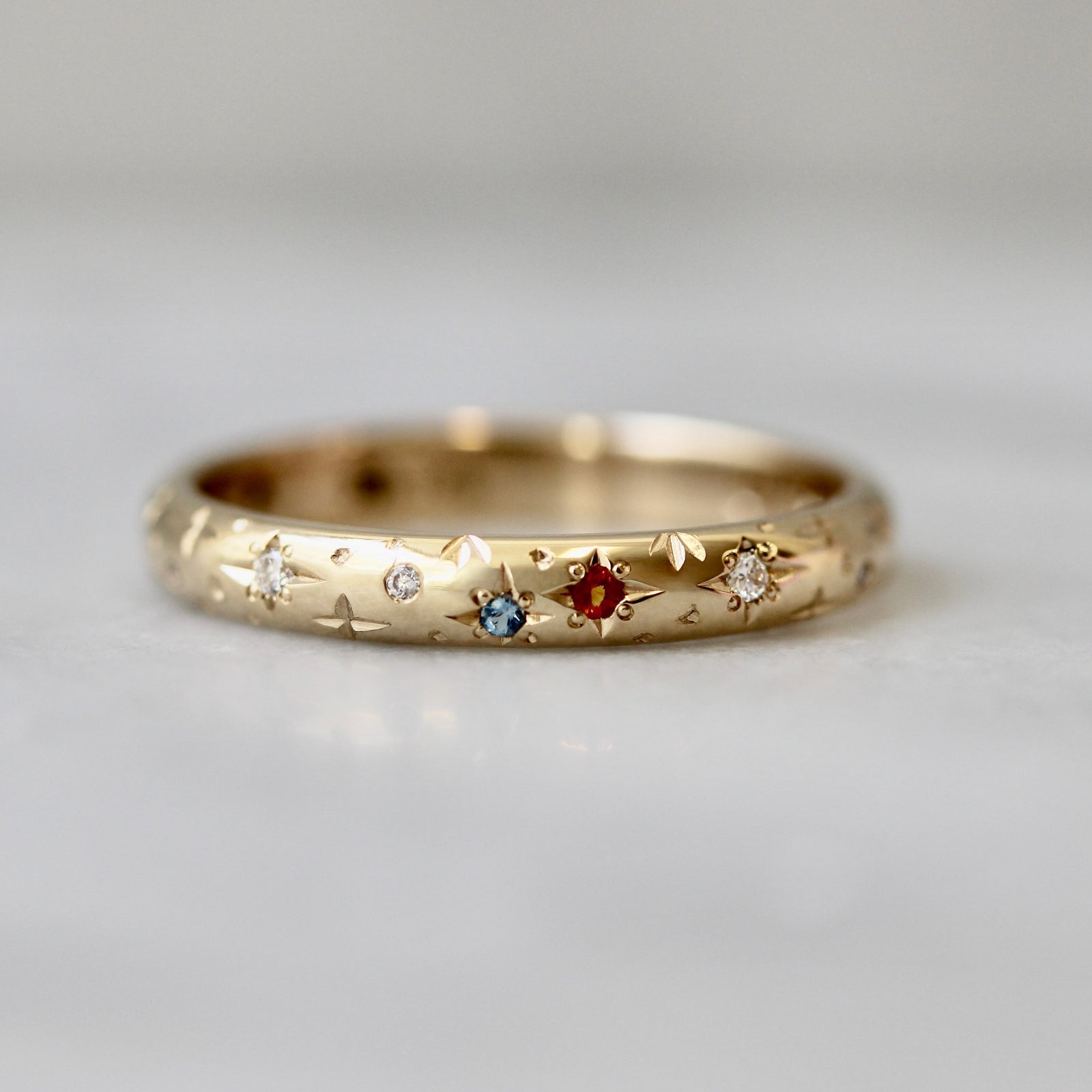 14k yellow gold custom wedding band with hand-engraved stars and star-set birthstones by Gem Breakfast