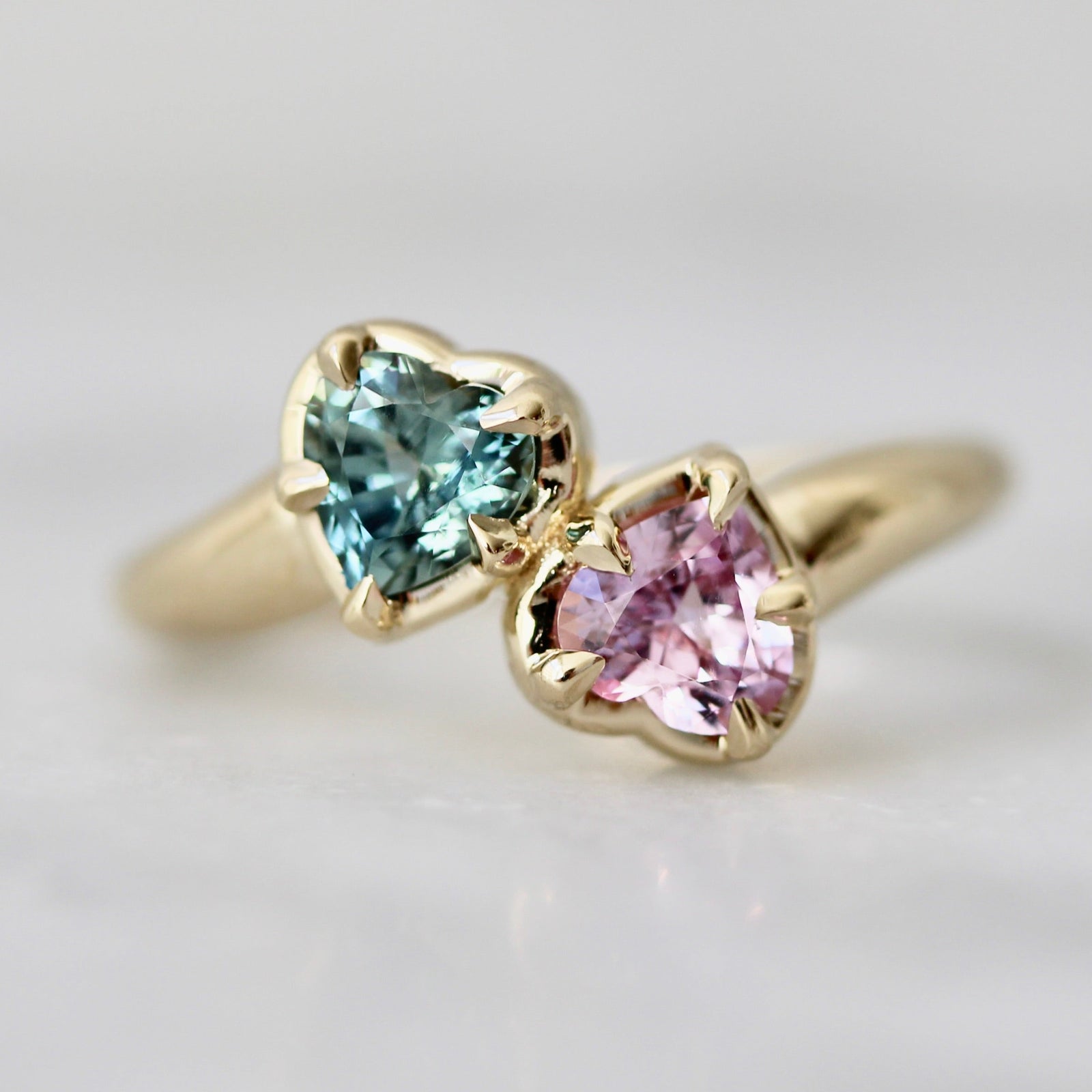 Custom engagement ring in a Toi et Moi setting with green and pink heart-shaped sapphires, Wicked-inspired by Gem Breakfast