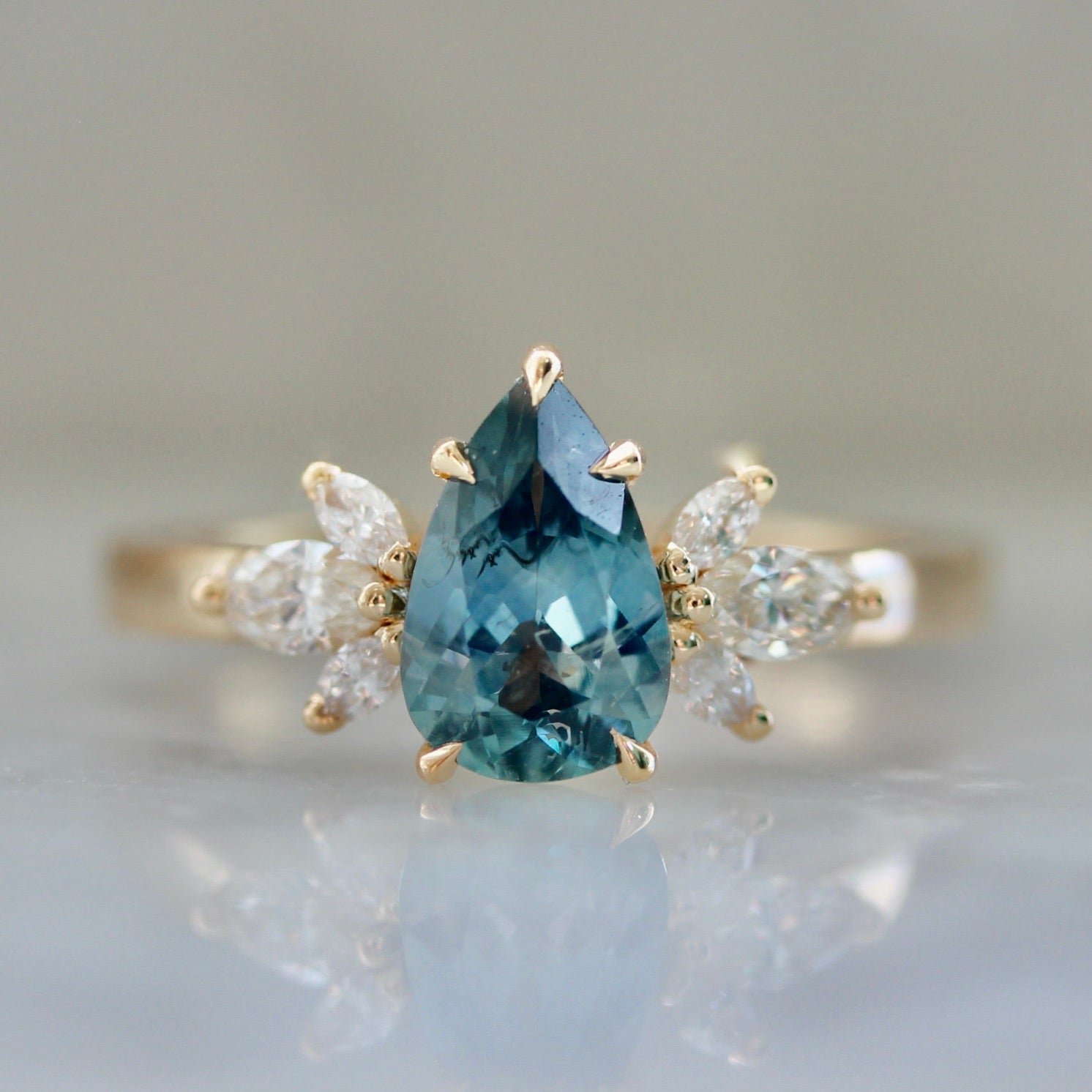 3654- Montana Blue Pear Cut Sapphire with Diamond Side Stones in Peach Gold