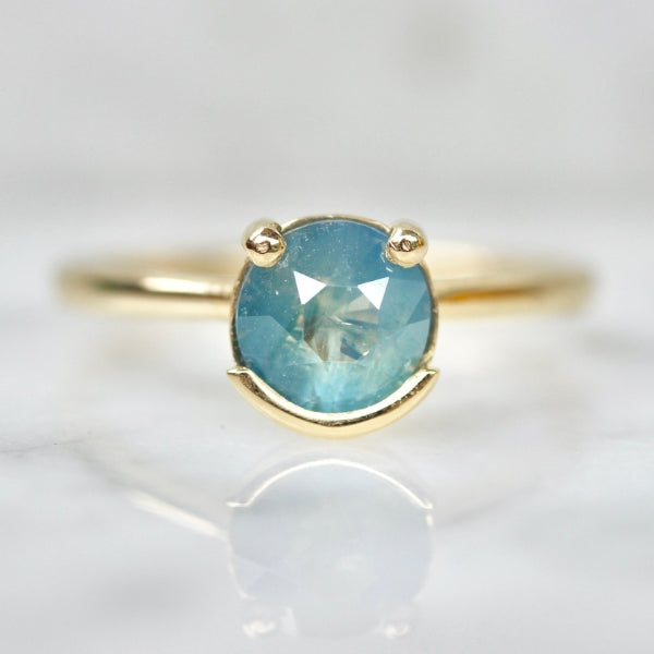 
            Poliwhirl Teal Round Brilliant Cut Opalescent Sapphire Ring