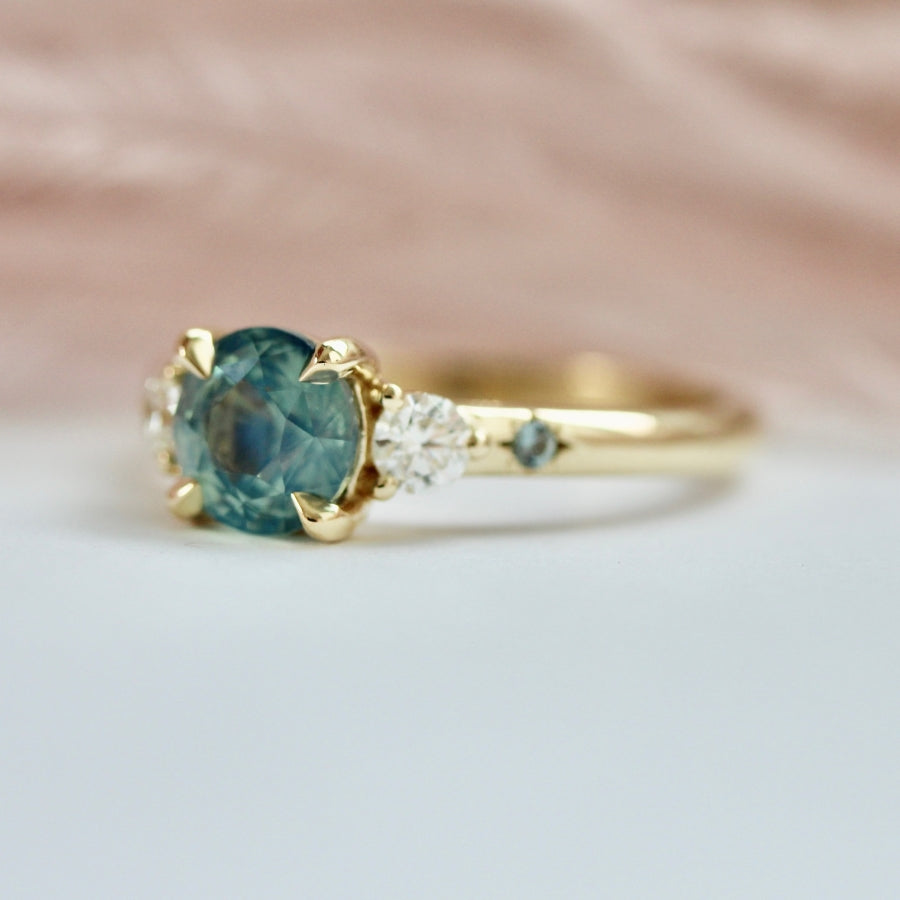 
            teal round brilliant cut sapphire ring