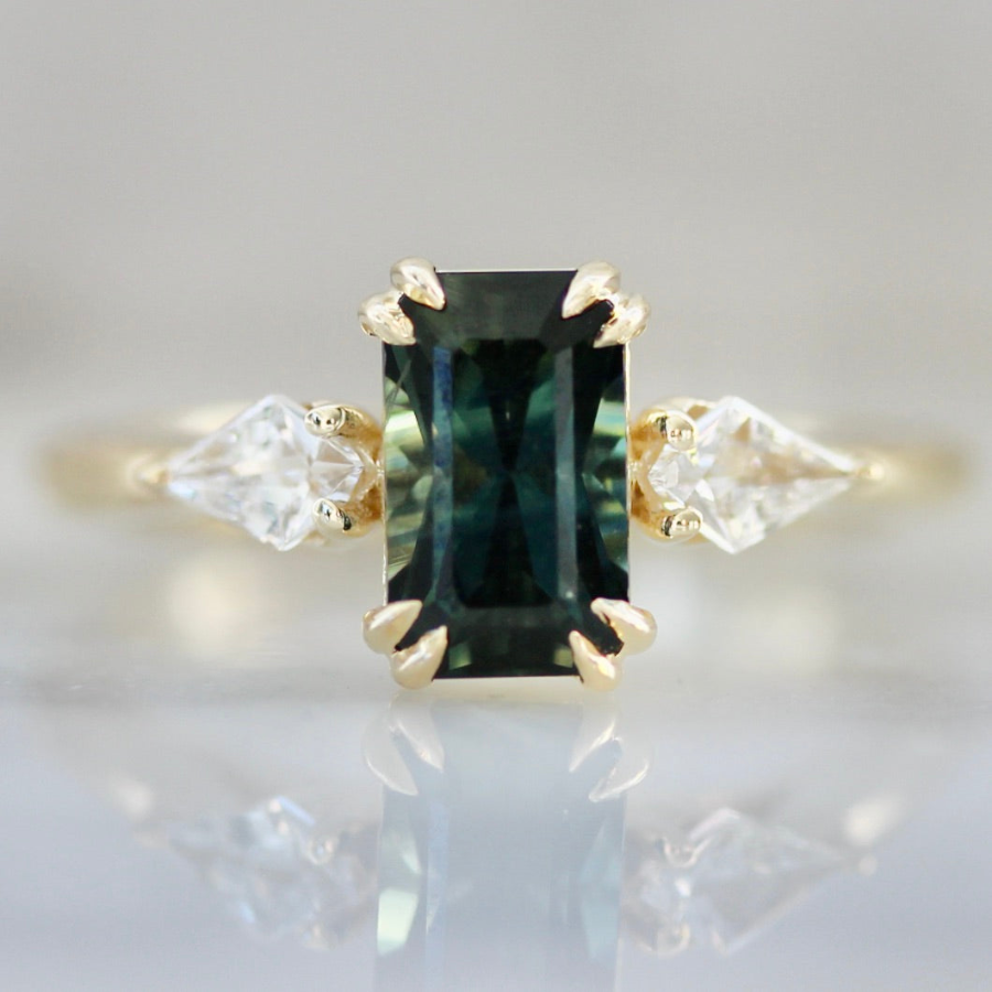 Emerald cut green sapphire engagement ring with kite diamond side stones in a custom design by Gem Breakfast