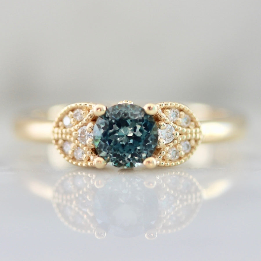 
            Marchioness Teal Round Brilliant Cut Sapphire Ring