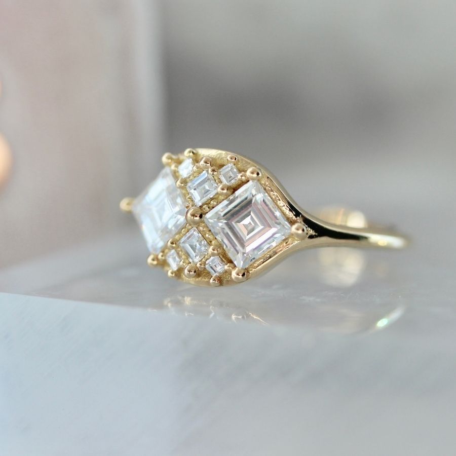 two white carre cut diamonds with six smaller white carre cut diamonds in yellow gold