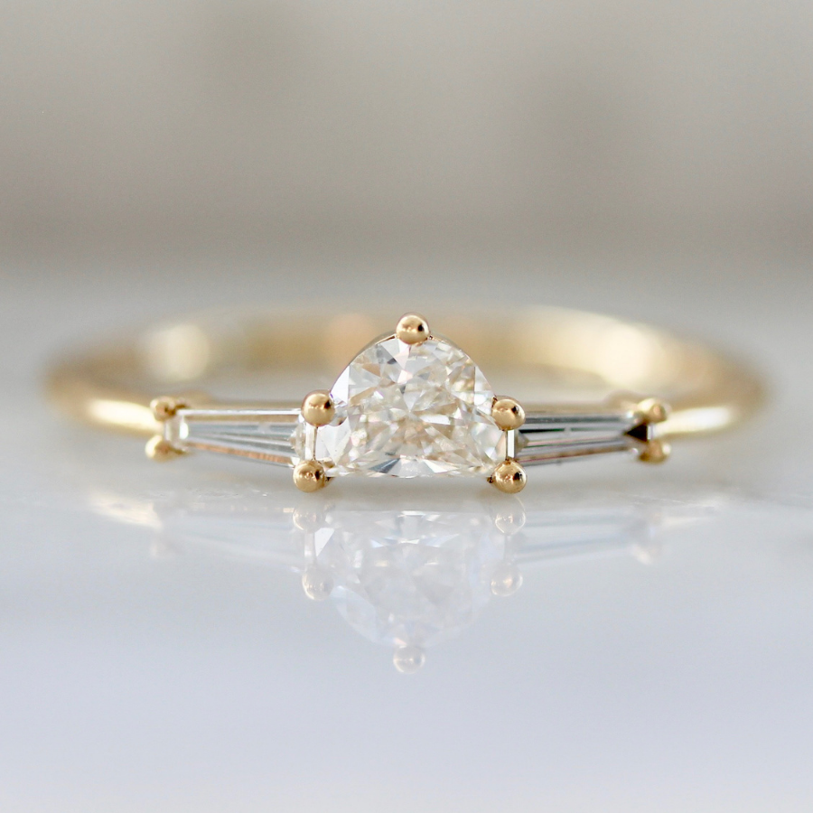 white half moon cut diamond with the tapered baguette sides in yellow gold