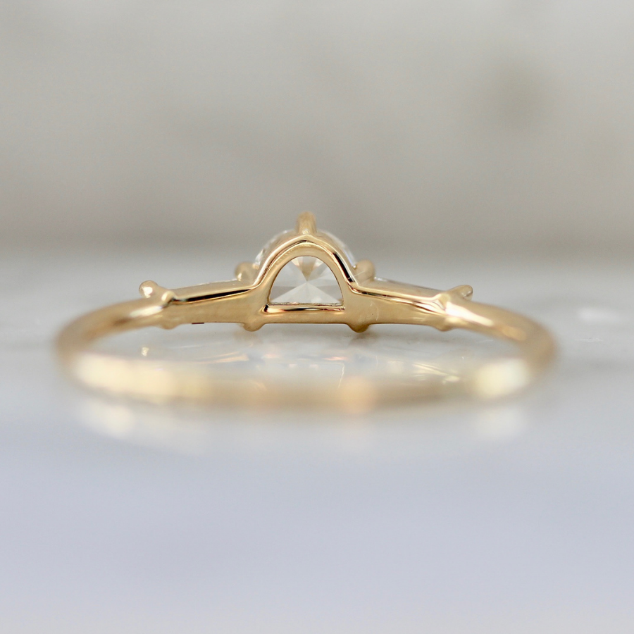 white half moon cut diamond with the tapered baguette sides in yellow gold
