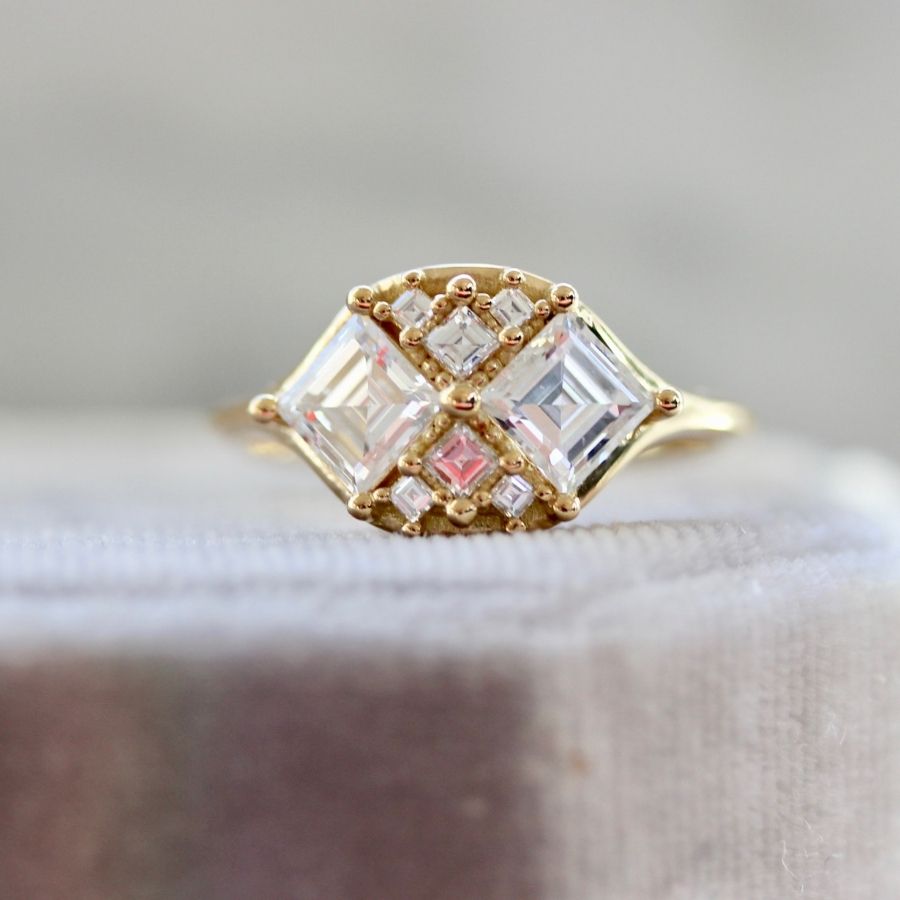 
            two white carre cut diamonds with six smaller white carre cut diamonds in yellow gold