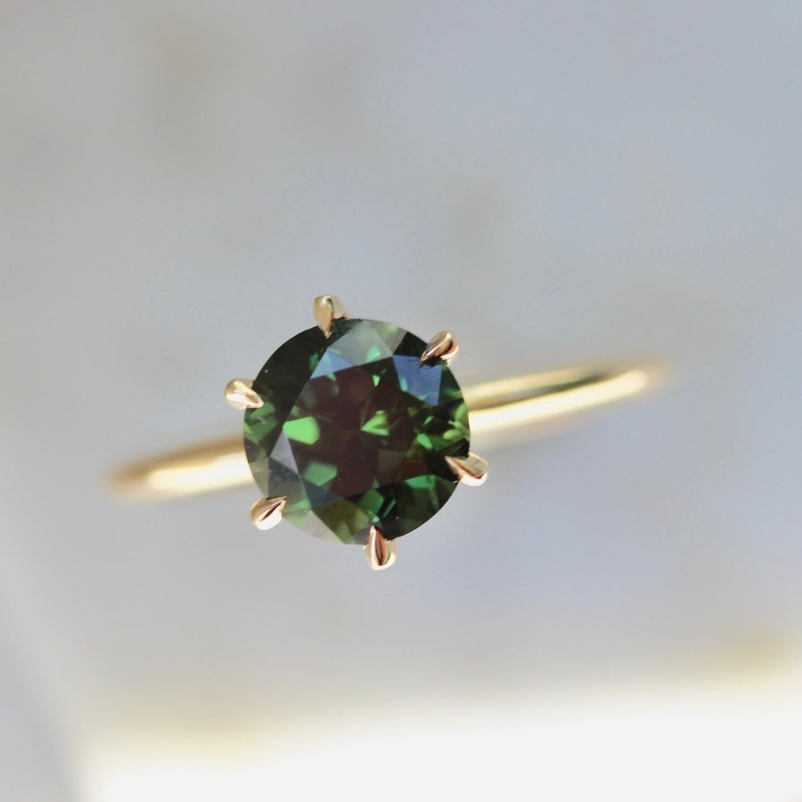 
            green round brilliant cut sapphire stella with 6 prongs in yellow gold