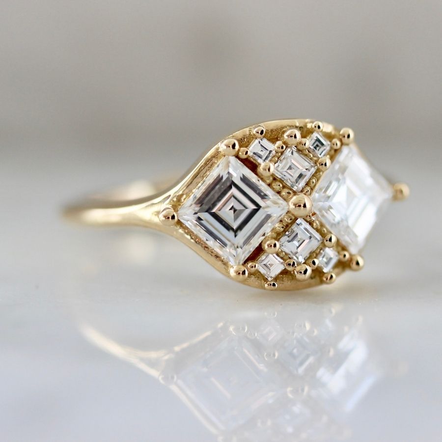 two white carre cut diamonds with six smaller white carre cut diamonds in yellow gold