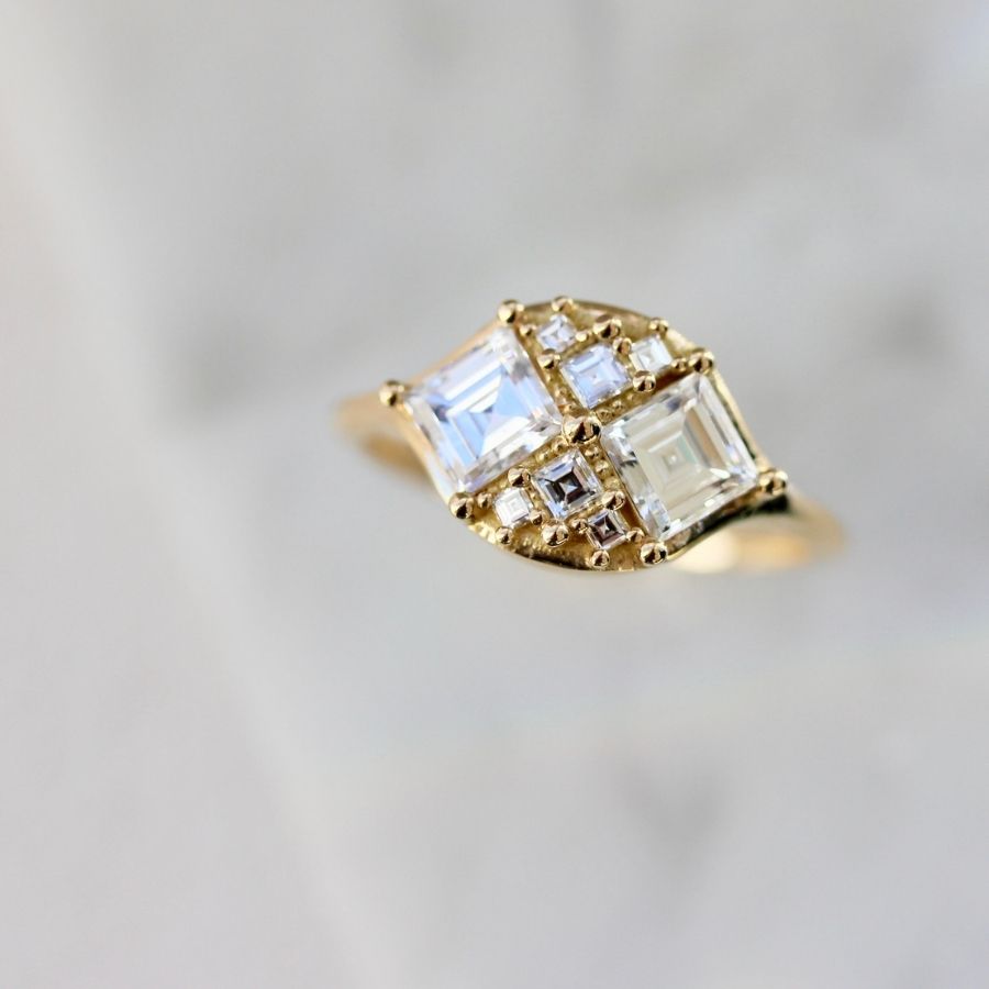 two white carre cut diamonds with six smaller white carre cut diamonds in yellow gold