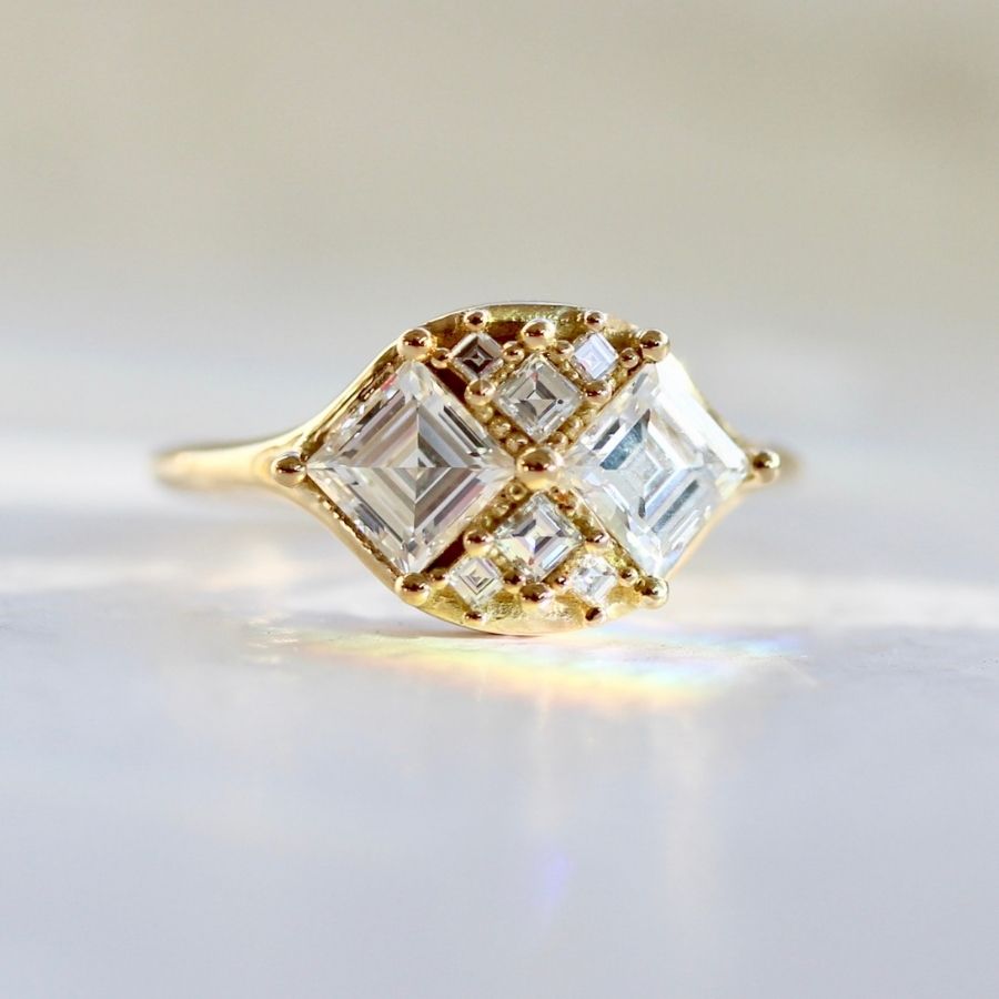 two white carre cut diamonds with six smaller white carre cut diamonds in yellow gold