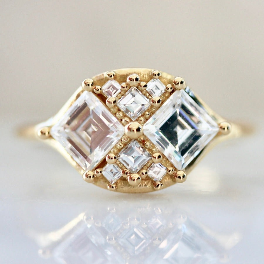 two white carre cut diamonds with six smaller white carre cut diamonds in yellow gold